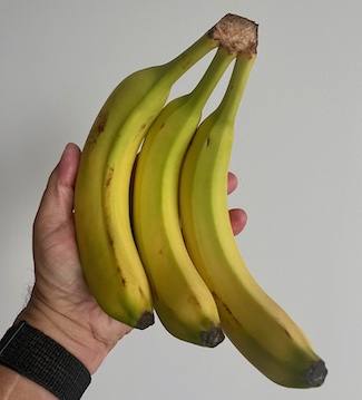 holding three bananas