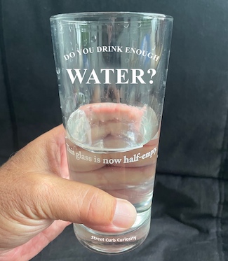 half empty glass of water promoting the podcast street curb curiosity