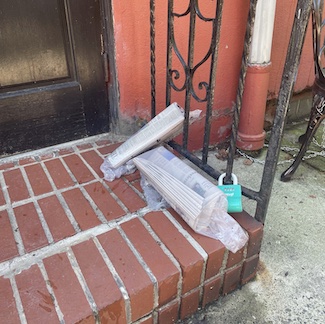 newspapers on a porch, untouched and unread