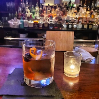 bourbon drink at a bar with a candle