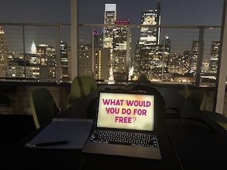 Philadelphia skyline at night with a laptop showing screen