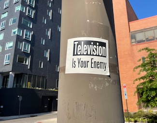 Television is the enemy poster on a pole in a city street