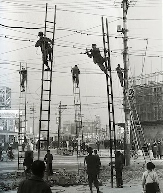 old photo of workers repairing overhead wires