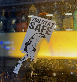 you stay safe sticker on window along busy street