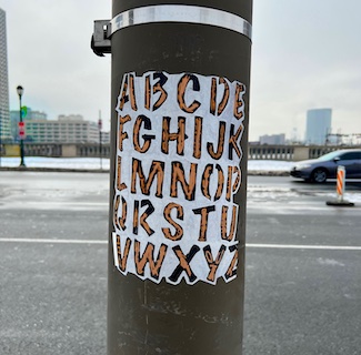 poster on pole showing all 26 letters suggesting everyone has the same creativity platform.