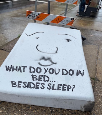 mattress on a sidewalk promoting a podcast about what you do in bed, besides sleep, for street curb curiosity