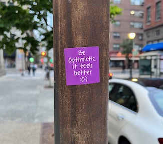 "Be Optimistic" sticker on street pole in Philadelphia for the daily motivational blog from the website www.caremoretoday.com 