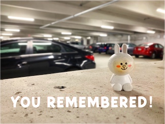 a smiling plastic toy bunny smiling in a parking garage