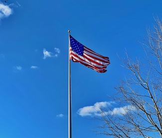 American flag waving on a flag pole for July 4 for the motivational daily bog from www.caremoretoday.com