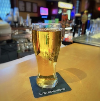 A glass of beer on a bar for national American beer day, plus a dad joke to help celebrate from the daily thought blog www.caremoretoday.com