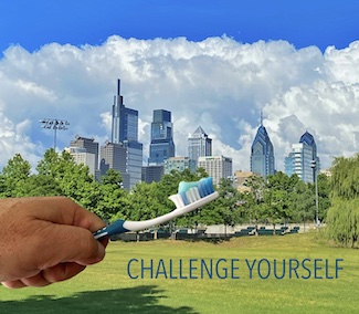 holding a toothbrush with your opposite hand over the Philadelphia skyline for national dental hygiene month, from the daily thought blog www.caremoretoday.com