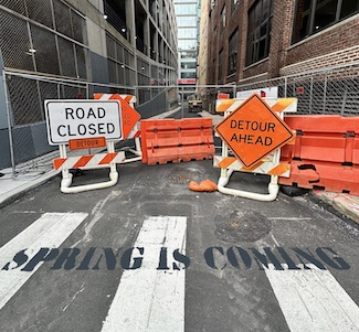 a city street closed with road construction signs.
