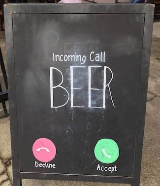 n outdoor bar sign showing that beer is calling on your phone