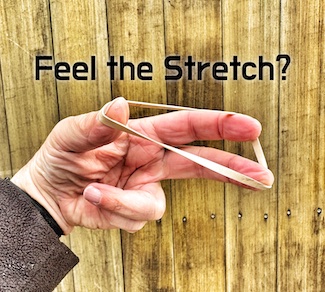 a stretched rubber band in one hand