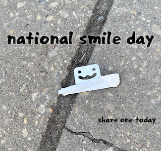 a piece of paper sharing a smile on a sidewalk for national smile day on the last day of May.