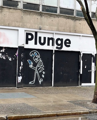 the word "plunge" on an empty store front on a city street