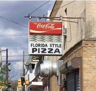 a Coca Cola lighted store sign claiming a pizza shop serves "Florida Style" Pizza