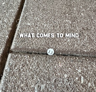 a sticker with the number 13 found on a city sidewalk