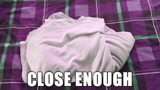 a badly folded bedsheet on a purple bed