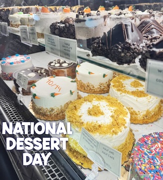 several fresh and delicious cakes on display in a store case for national dessert day