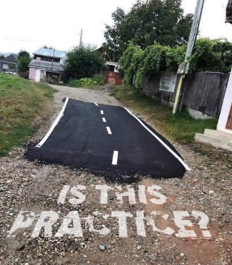 a strip of fresh blacktop roadway laid down in a back alley