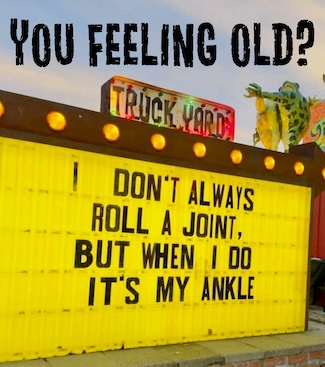 a bright yellow outdoor sign about pain as you get older