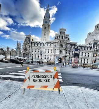 a permission required sign across the street from the city hall building in center city philadelphia