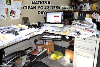 a very messy desk and office for national clean of your desk day in January
