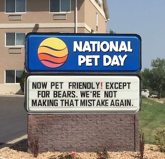 a fun hotel street sign about them being pet friendly with a funny thought about bears