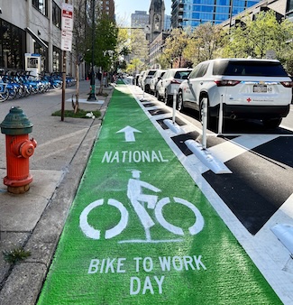 a green bike lane on a busy city street in philadelphia to celebrate national bike to work day in May