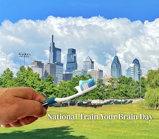 the Philadelphia sky line with a left hand holding a tooth brush for national train your brain day in october