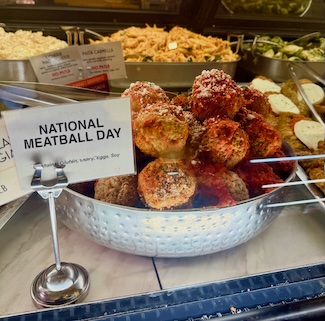 a grocery store display of meatballs for sale for national meatball day