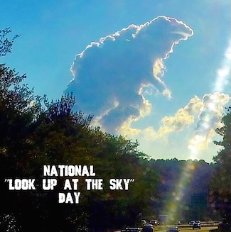A large cloud that looks just like Godzilla, over a highway, for national look up at the sky day in April.