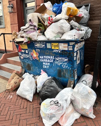 a large pile of garbage and trash bags in a refuse collection bin, for national garbage man day