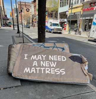 two old very used mattresses on a city street, for a podcast episode about buying a new one