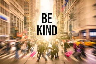 a busy city street with a lot of people with a reminder to be kind.