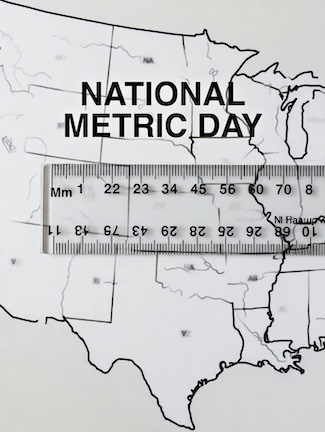 a black and white image of a metric ruler laying on a state map of the USA for national metric day