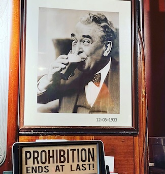 A poster in a bar of a smiling man enjoying a beer for the end of prohibition.