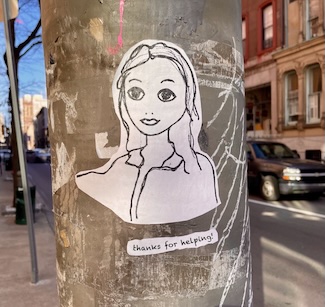a positive piece of street graffiti of a young woman on an old city pole