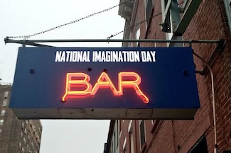 An orange neon bar sign on a city street for national imagination day in January