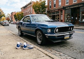 A classic blue ford mustang muscle car from 1969 on a old city street for a fun dad joke on world (or global) running day in June