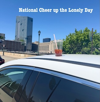 a soft drink on the roof of a moving car to get people's attention on national cheer up the lonely day in July