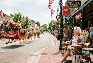 a fun and fake take on christmas in July with Santa and reindeer on a. small town street, with grandma sitting on the sidewalk with a margarita by a tequila bar