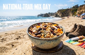 a bowl of tasty trail mix with chocolate and nuts on a California beach for national trail mix day on the last day of August