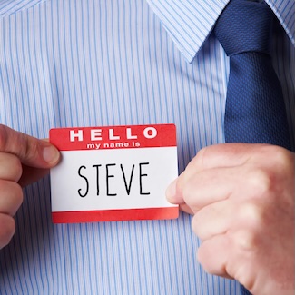 a man in a blue dress shirt and tie, with a red name tag showing his name is Steve for national Steve Day